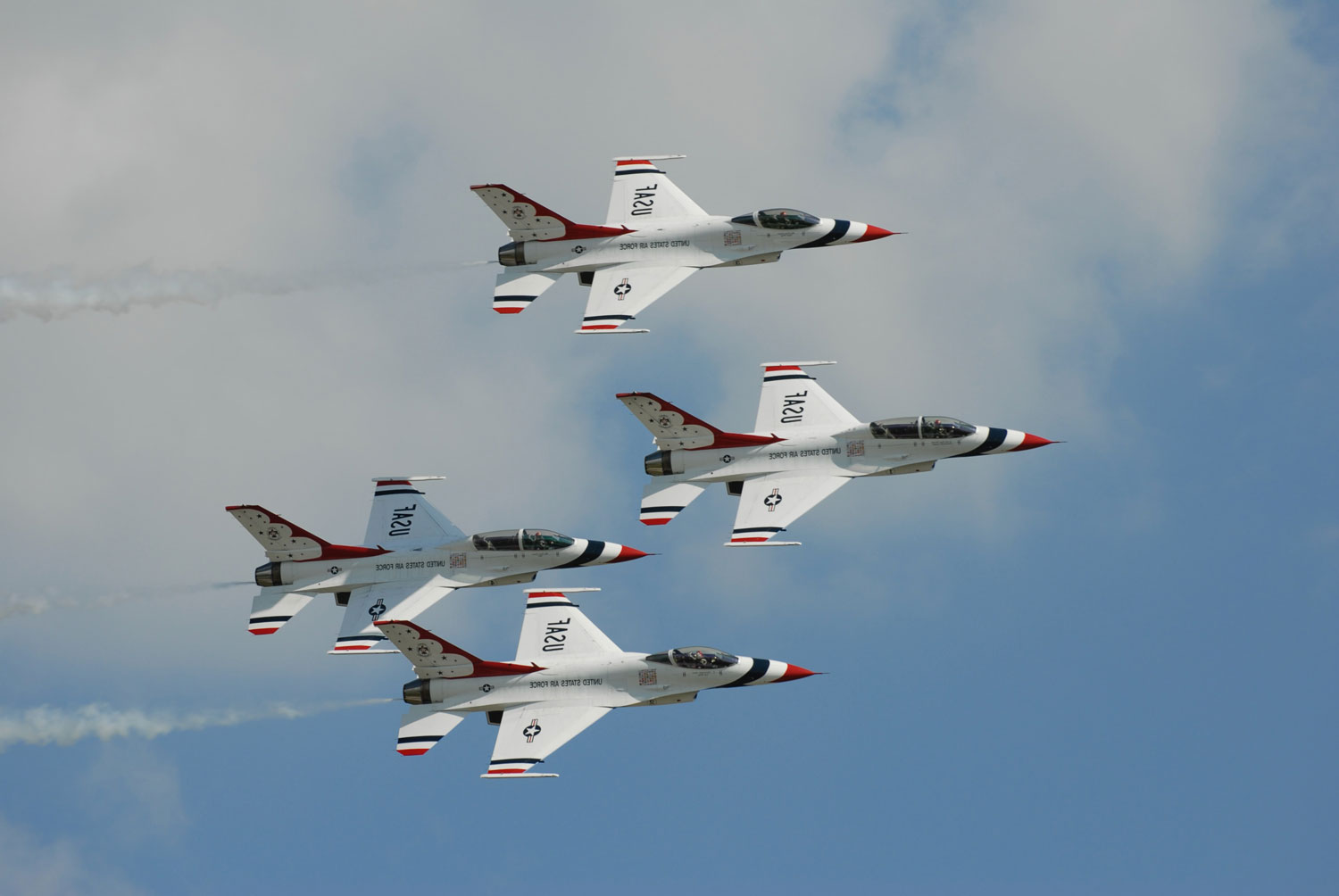 four aircrafts flying through blue skys