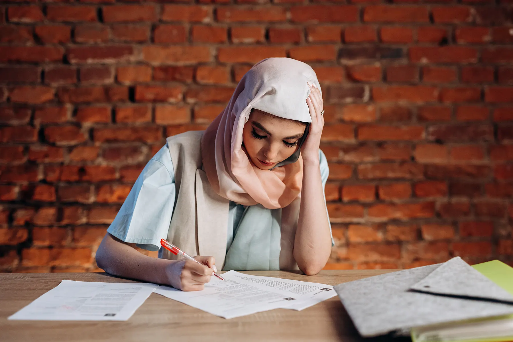 woman at a table working with multiple documents