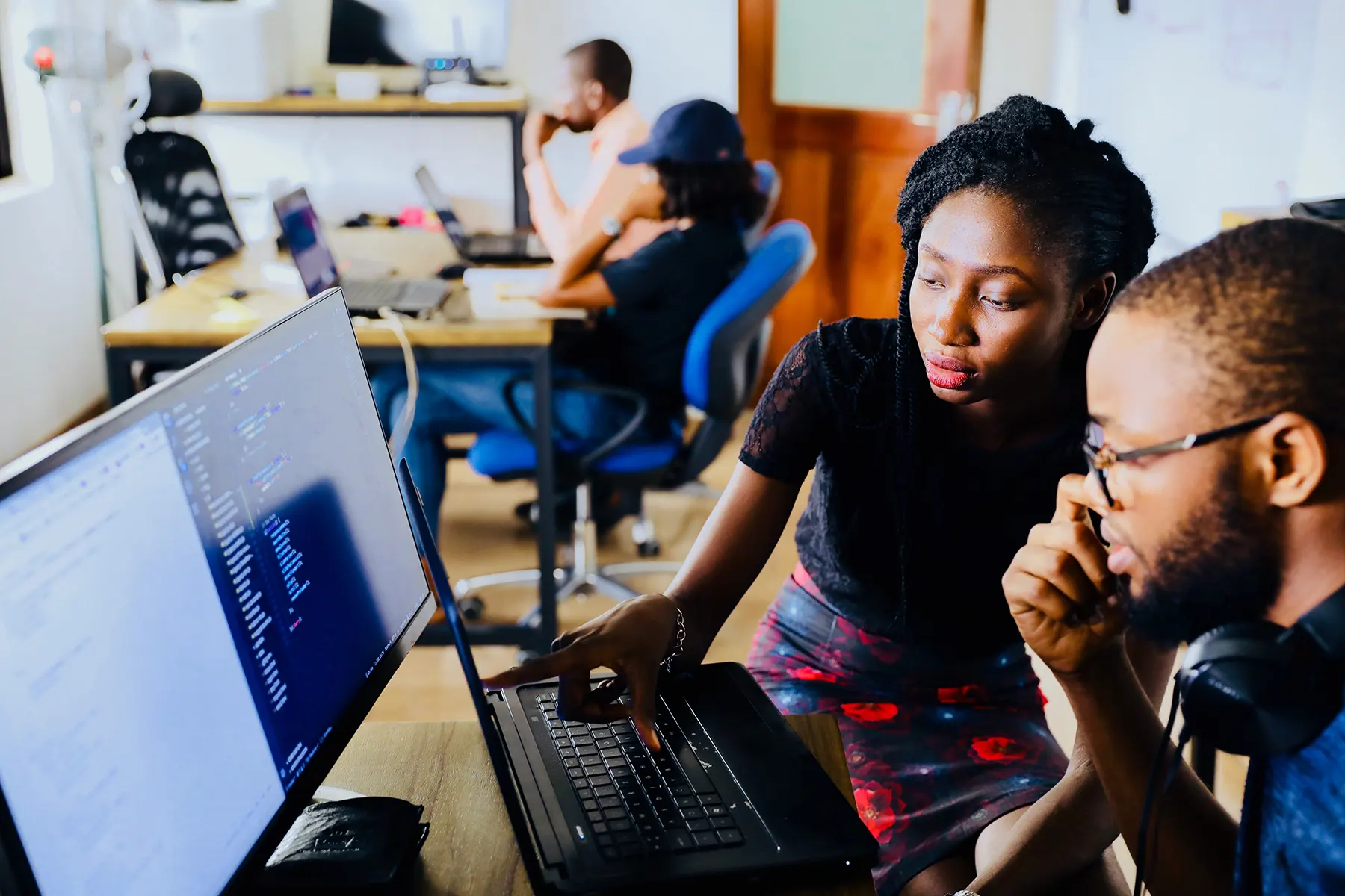 trainer giving a student hands on help on the computer