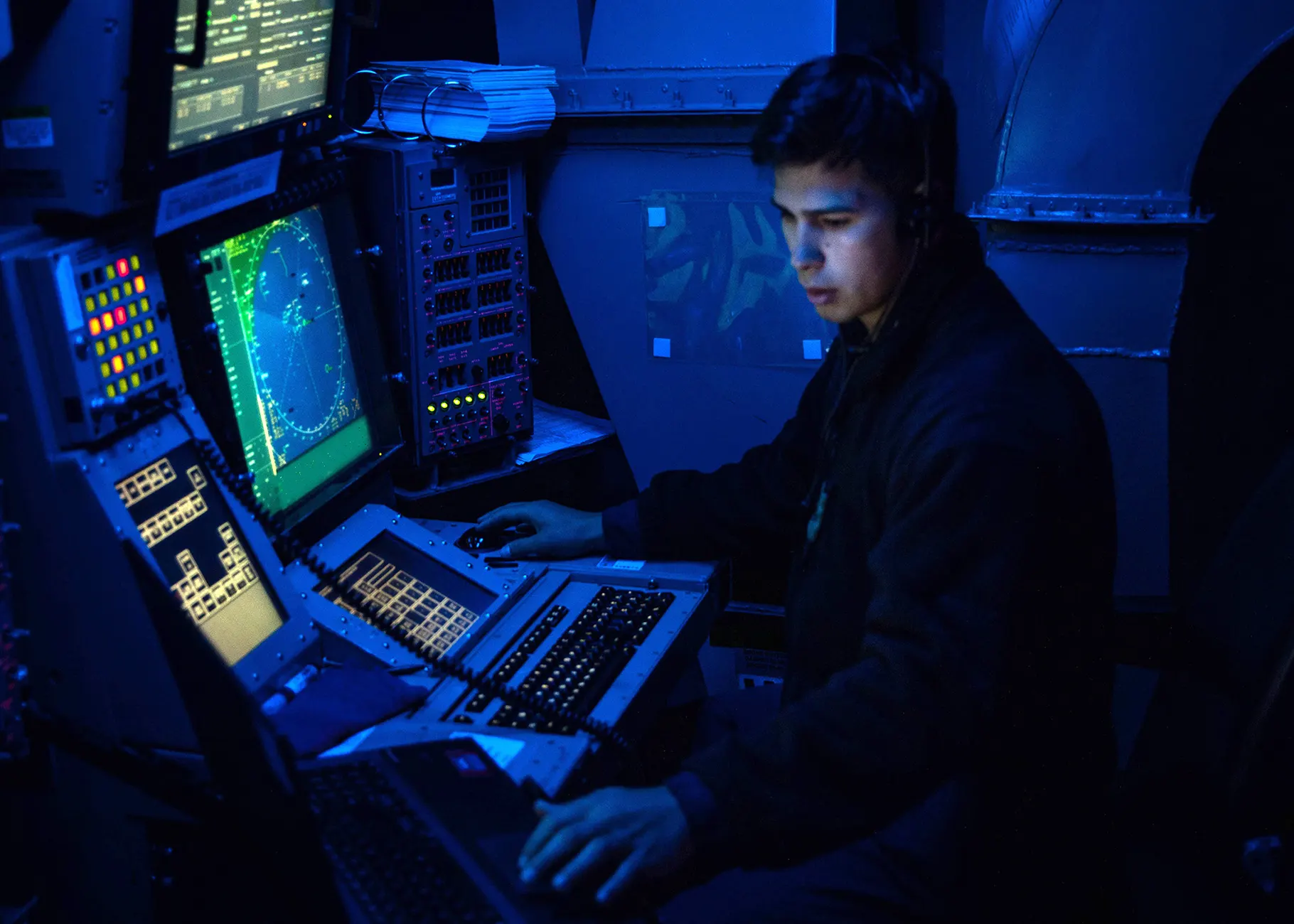 security engineering working in a dark room with multiple screens